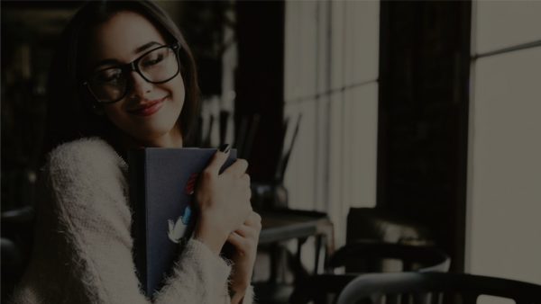 woman hugging journal with smile on face